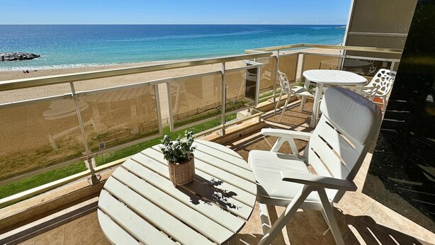 Ein Balkon mit Blick auf Strand und Meer.