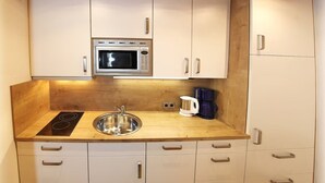 A kitchen with a microwave, sink, stove, and cabinets.