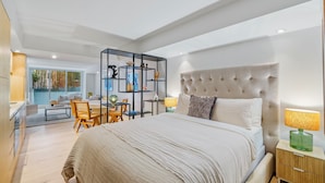 A modern bedroom with a large bed, a nightstand, a desk, and a chair. - Bondi Pacific Studio - Managed by X Hospitality (Bondi Beach)