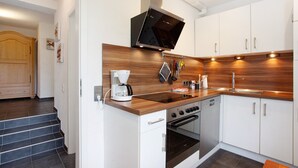 A modern kitchen with a built-in oven, microwave, and coffee maker. - Apartment "Keil" with Mountain View, Private Terrace & Wi-Fi (Balve)