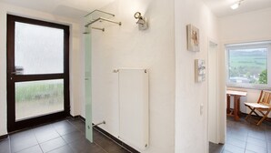 A room with a radiator, a glass door, a window with a view, and a chair. - Apartment "Keil" with Mountain View, Private Terrace & Wi-Fi (Balve)