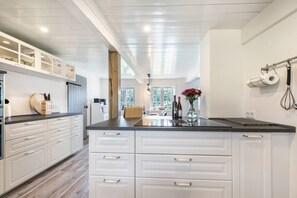 Una cucina moderna con mobili bianchi, un piano di lavoro nero e un'isola centrale.
