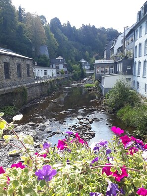 Une rivière traverse une ville où se trouvent des bâtiments en pierre et un restaurant appelé « RESTAURANT Alte Herrlichkeit ».