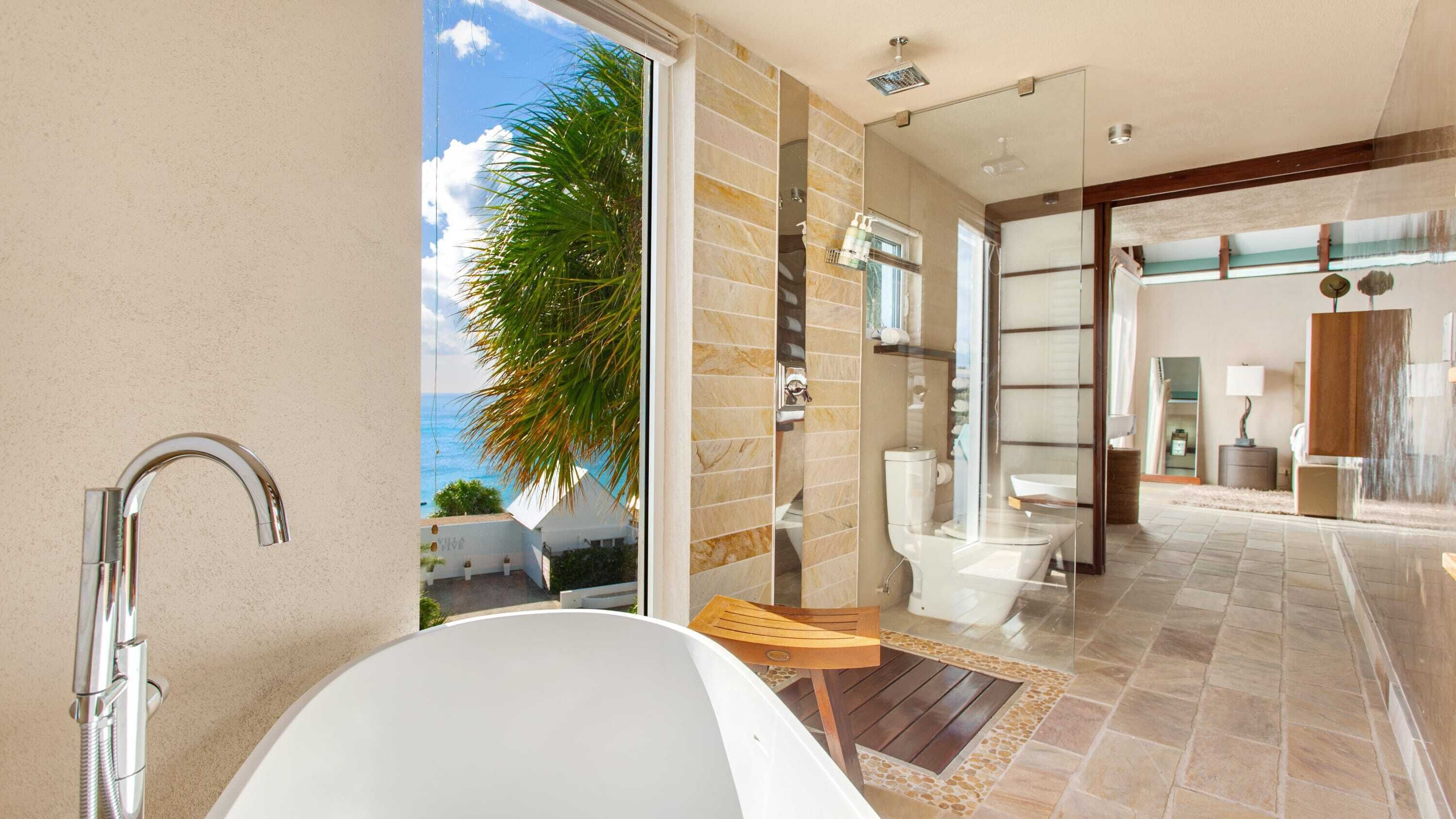 Un baño moderno con bañera, ducha y zona de ducha con paredes de vidrio.