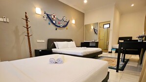 Una camera d'albergo con due letti, una ventola a soffitto, uno specchio grande e una scrivania.