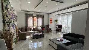 A modern living room with a sofa, coffee table, and decorative plants. - Yang Bhutan Hotel (Paro)