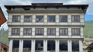 A two-story building with a traditional architectural style, featuring a balcony with a sign that reads "YANG". - Yang Bhutan Hotel (Paro)
