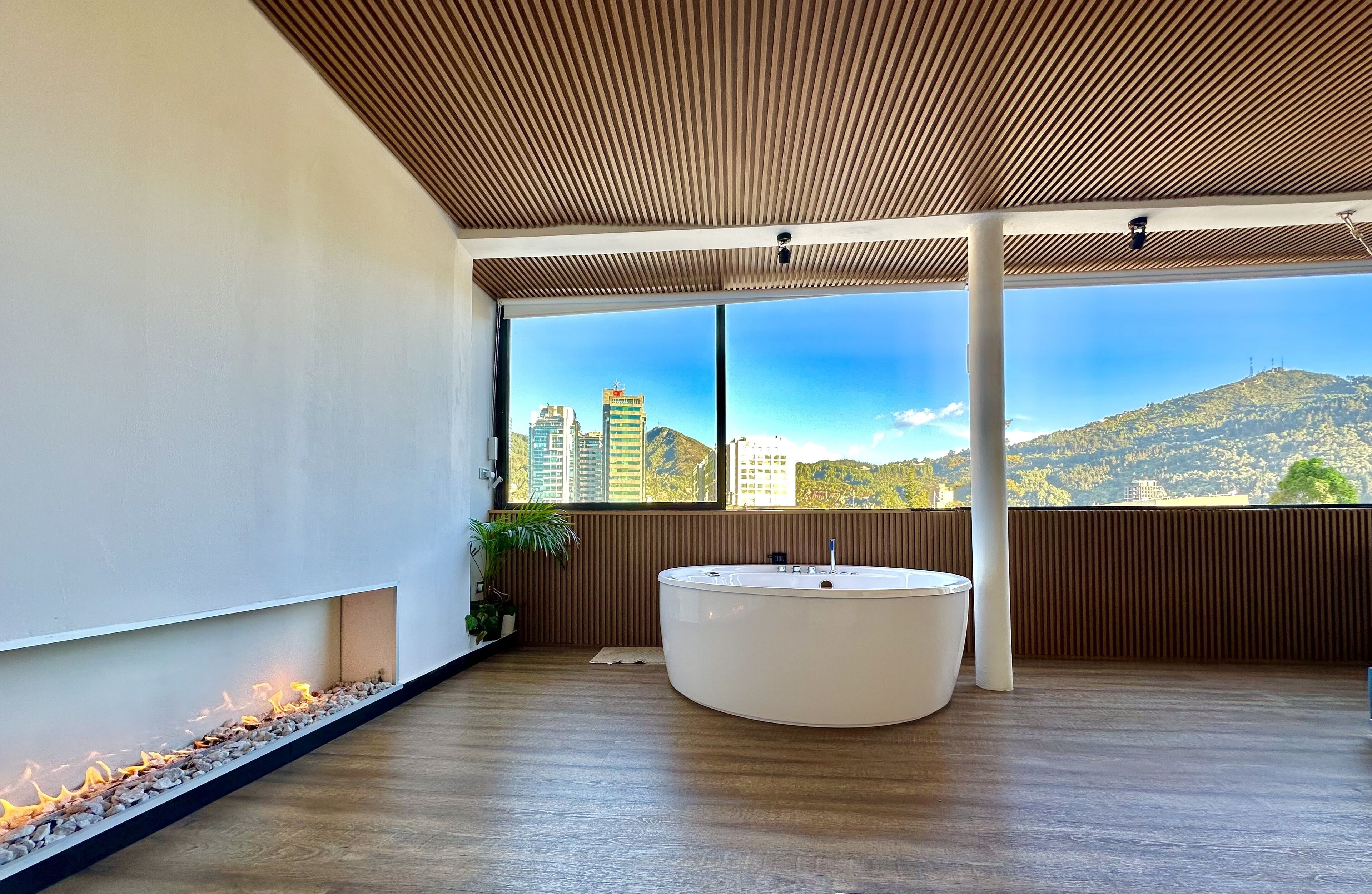 Une salle de bain moderne avec une grande fenêtre, une baignoire et un plafond en bois.