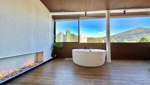 Une salle de bain moderne avec une grande fenêtre, une baignoire et un plafond en bois.