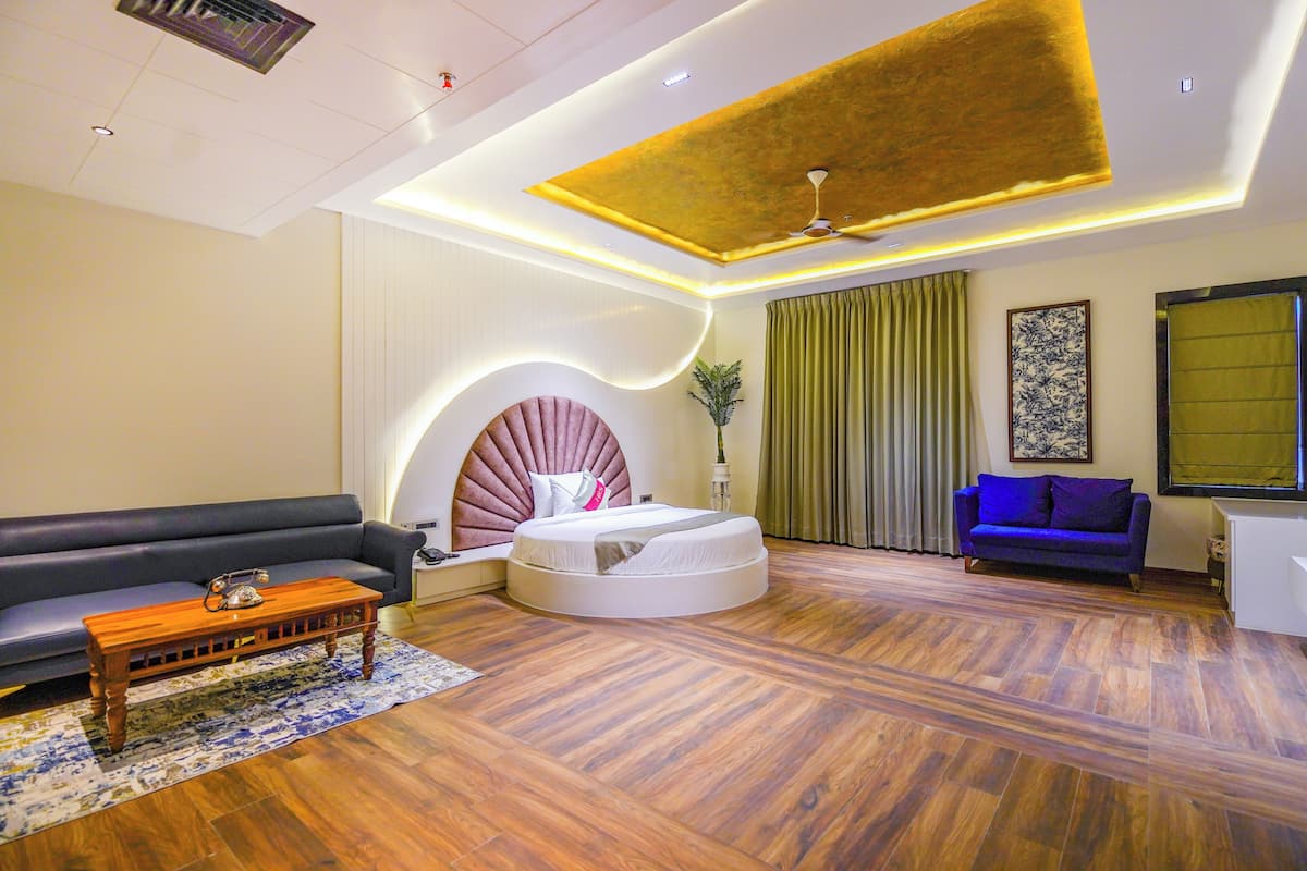 Un salon moderne avec un lit rond, un canapé et un fauteuil bleu.
