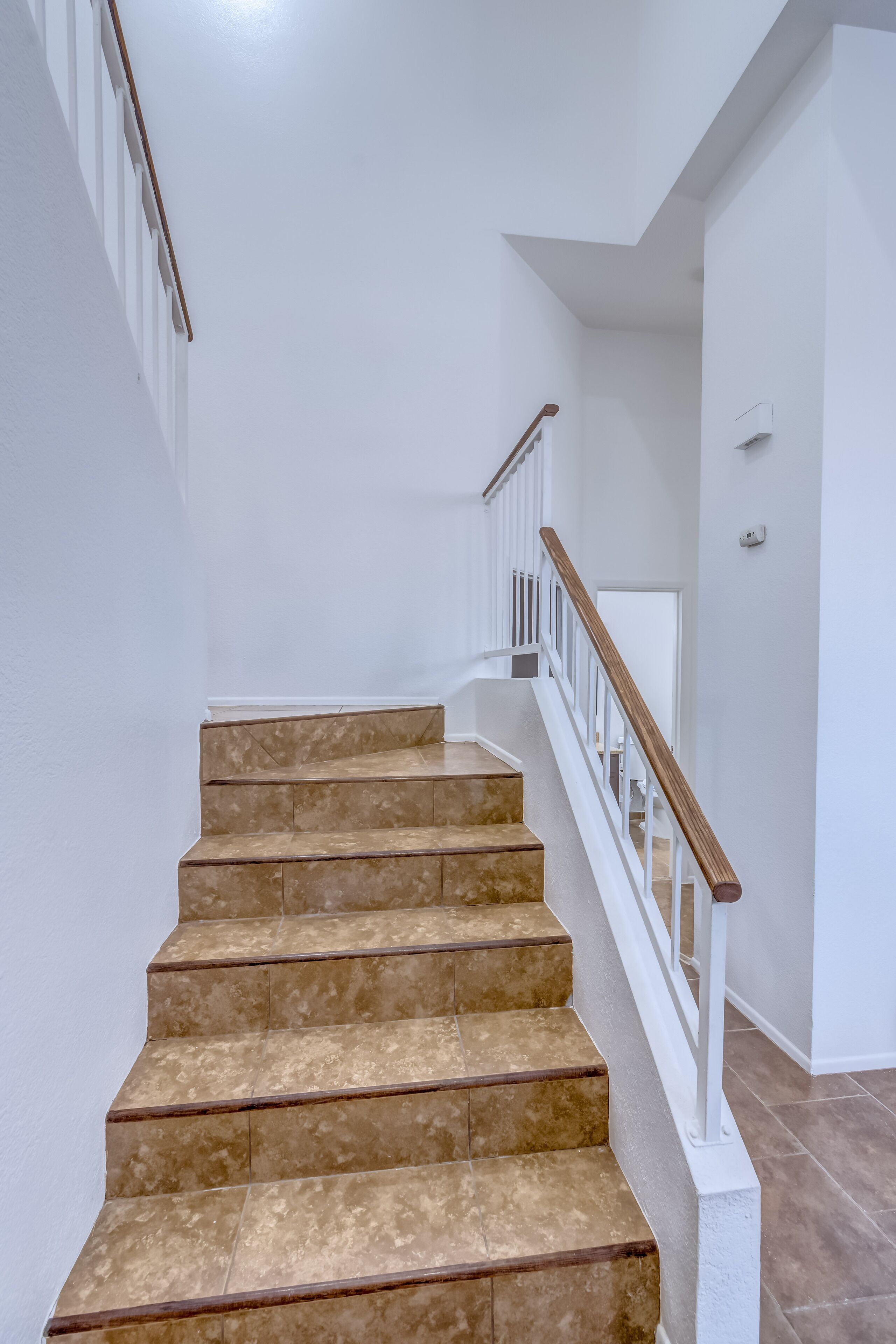 A staircase with beige steps and white railings.