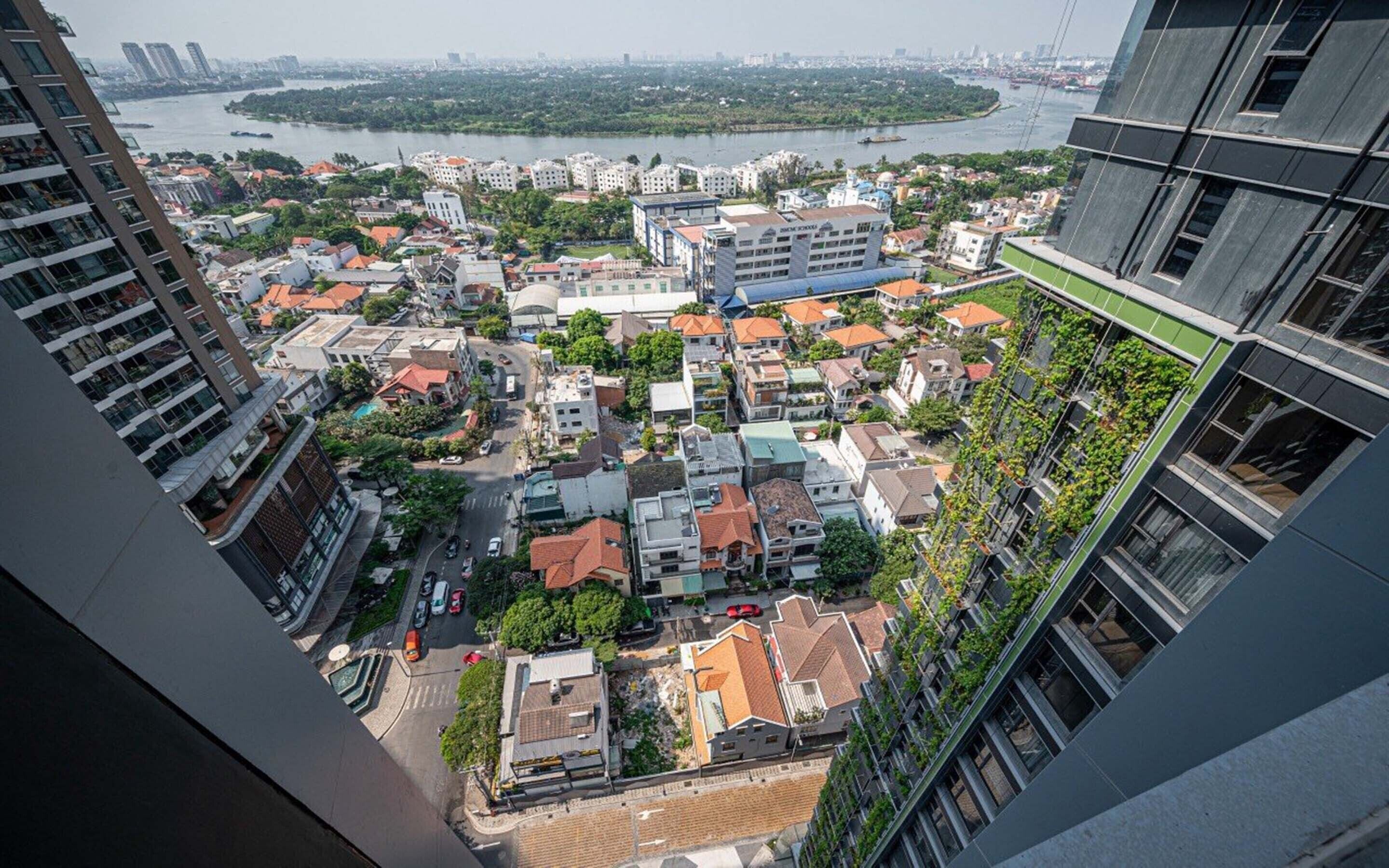 A high-rise building with a view of a cityscape, including a river and distant buildings.