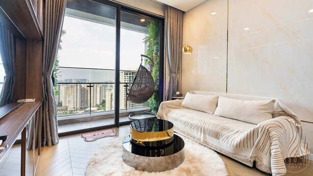 A modern living room with a sofa, a round coffee table, and a hanging chair. - The LUMIERE Riverside Residence (Ho Chi Minh City)
