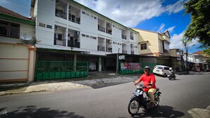 A multi-story building with a sign indicating a room is available. - Omah Manahan (Surakarta)