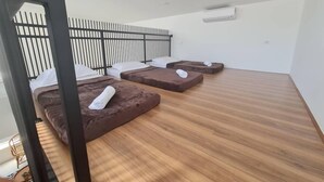 A room with three massage beds, a wooden floor, and a black metal railing. - Garden Home Ipoh (Ipoh)