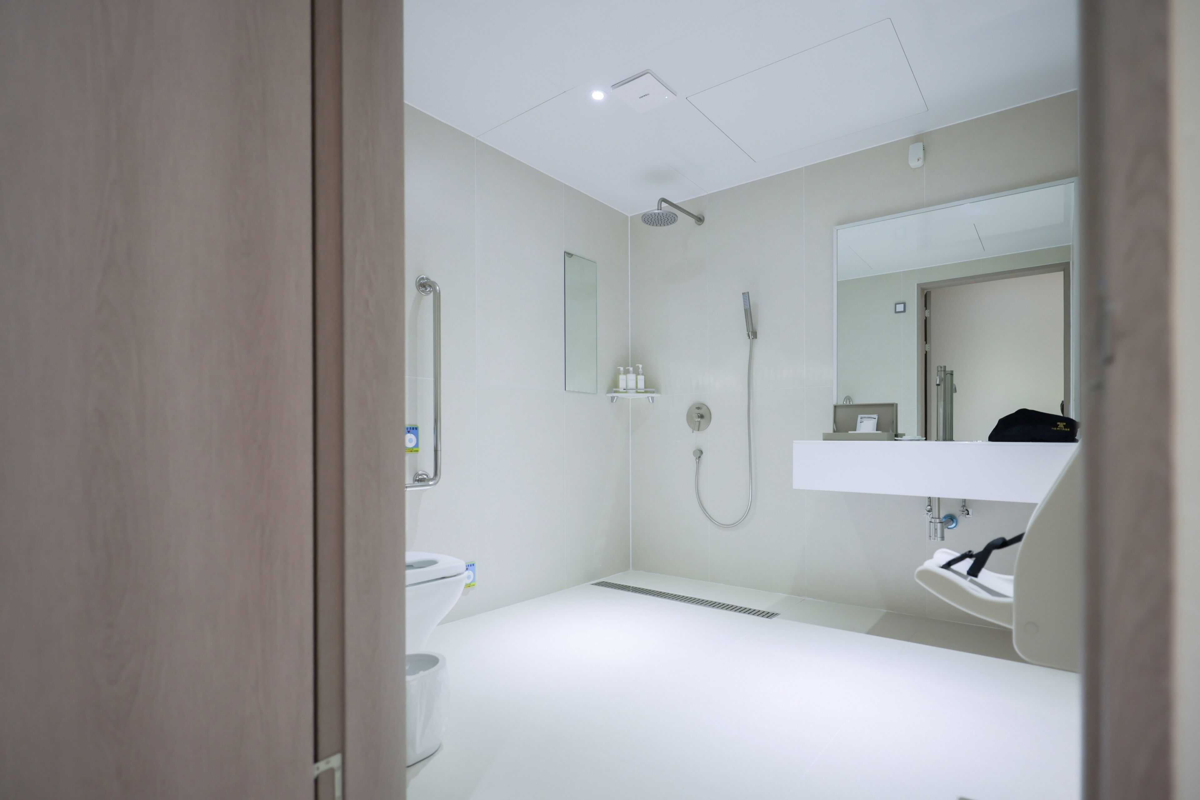 Een moderne badkamer met douche, toilet en wastafel.