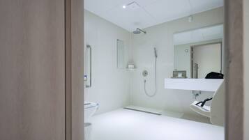 Une salle de bain moderne équipée d’une douche, de toilettes et d’un lavabo.
