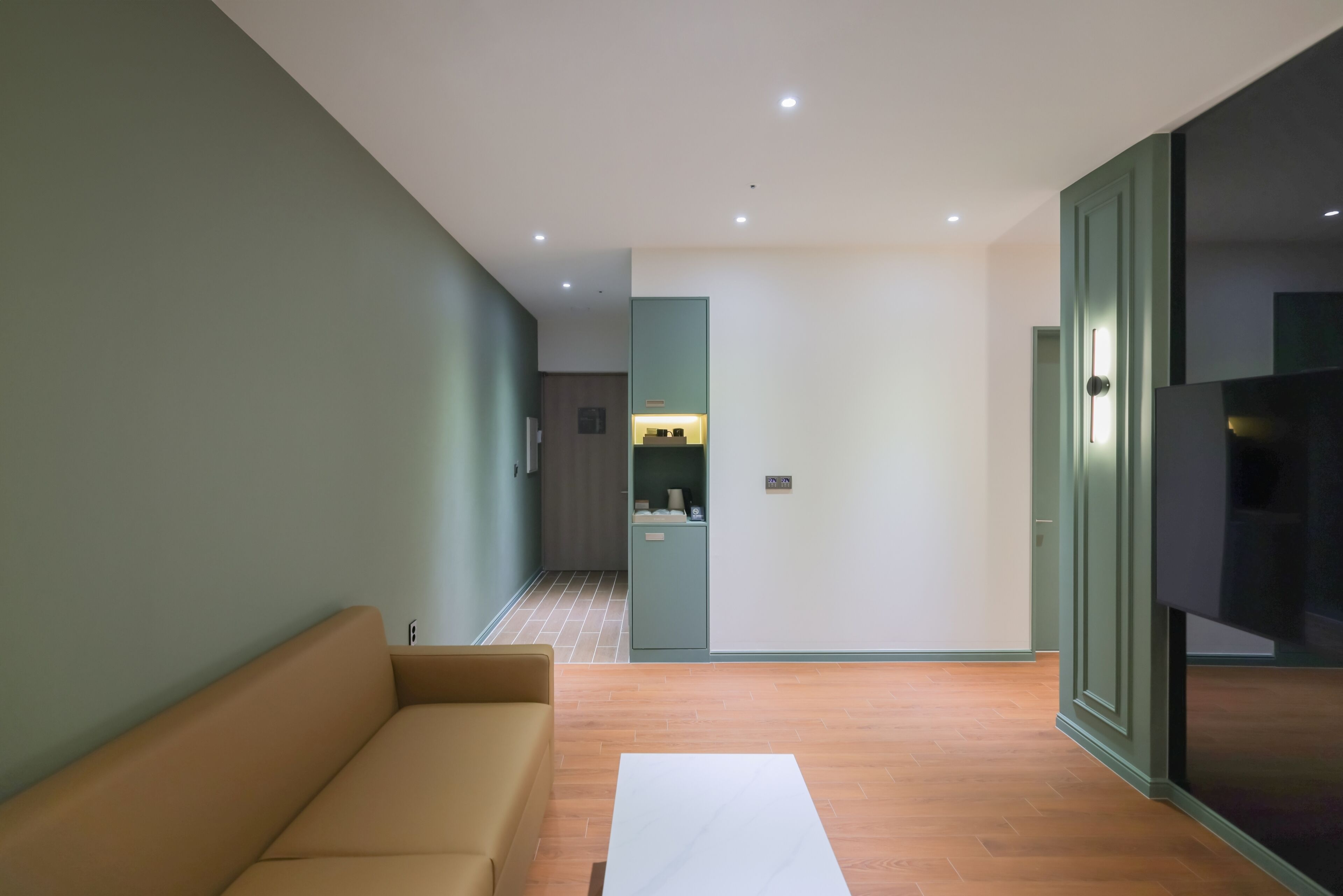 Una sala moderna con sofá, mesa de centro y televisor.