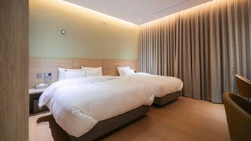 Una habitación de hotel moderna con una cama grande, mesitas de noche y una cortina.
