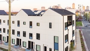 A modern multi-story building with a flat roof, large windows, and a visible parking area. - Conway Buyout - 2 Units by AvantStay | Sleeps 14 (Nashville)