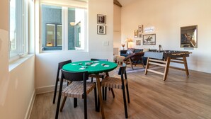 A room with a foosball table, a green table with poker chips, and a sofa. - Conway | Professionally Managed Buyout in DT Nash (Nashville)
