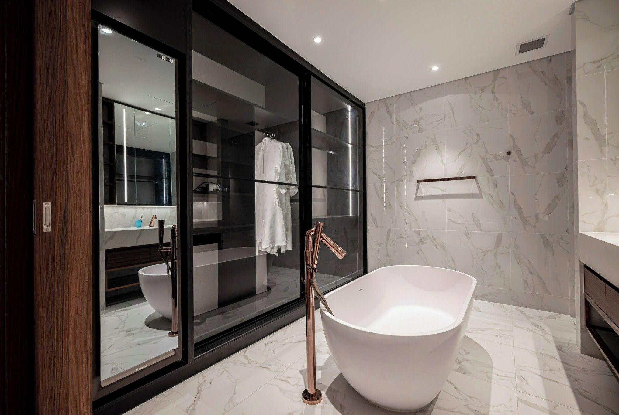 Une salle de bain moderne avec une baignoire sur pieds, une douche à l’italienne et un revêtement de sol en marbre.