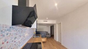 Una cocina moderna con microondas integrado, encimera de madera y salpicadero estampado.