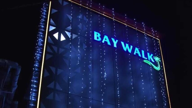 A building with the sign "BayWalk" and a sign below stating "Rooms, Restaurant, Lounge".
