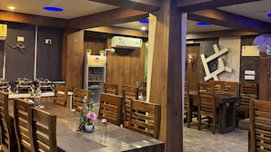 A restaurant with wooden furniture and blue ceiling lights.