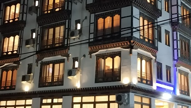 A multi-story building with traditional architectural style, featuring multiple balconies and large windows.