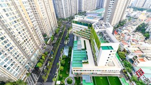 Un immeuble résidentiel de grande hauteur, composé de plusieurs étages, doté d’une cour intérieure avec des espaces verts, et entouré d’un quartier urbain comprenant d’autres bâtiments.