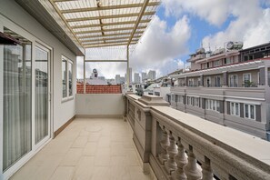 A balcony with a pergola, a view of the cityscape, and a building with a clock tower. - El Ocaso Boutique Hotel (Ho Chi Minh City)