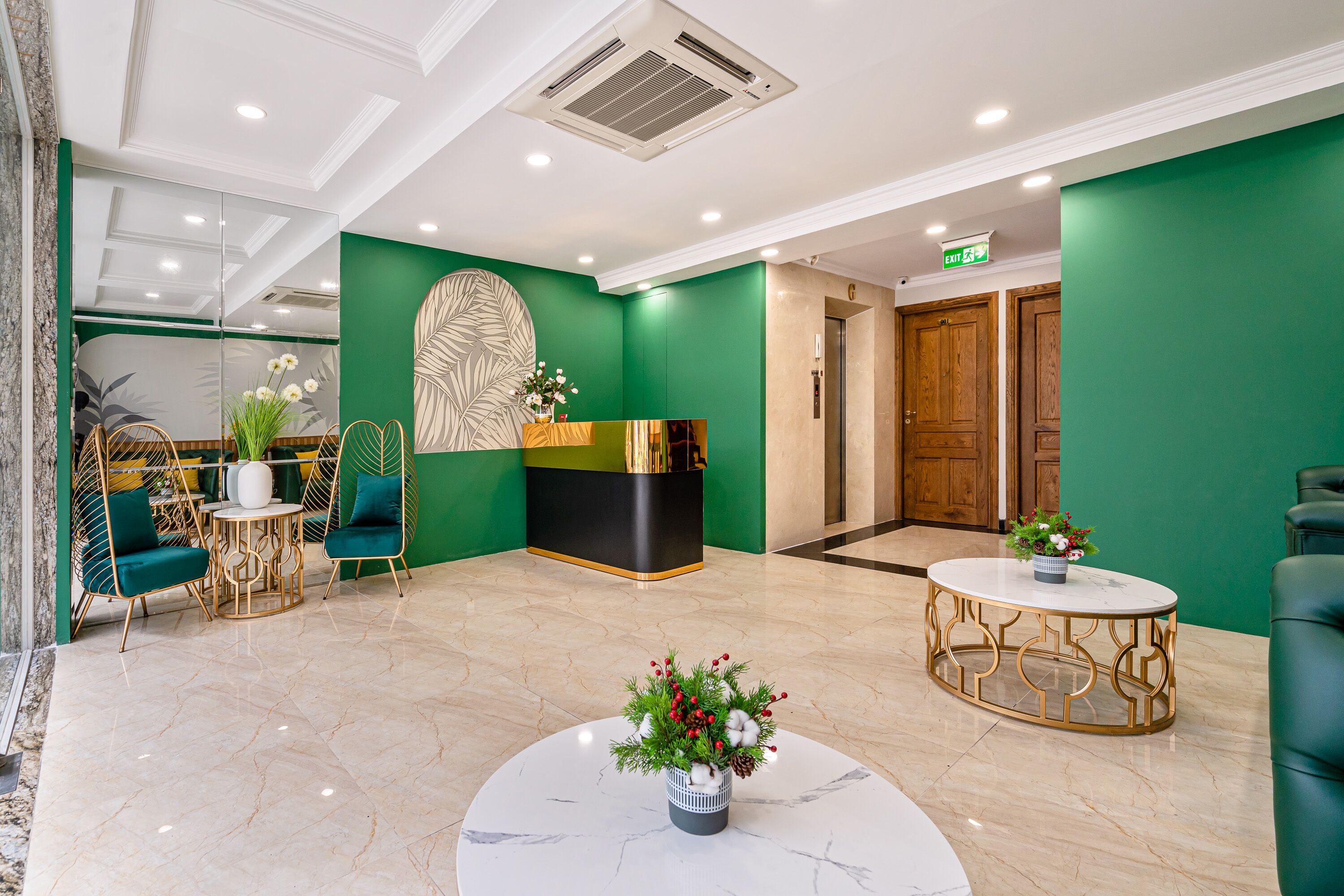 A lobby with a green wall, a reception desk, a wooden door, and a marble floor.