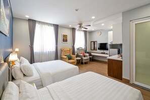 A hotel room with two beds, a desk, a chair, a television, and a ceiling fan. - El Ocaso Boutique Hotel (Ho Chi Minh City)