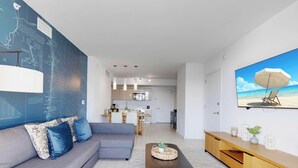 Una sala de estar moderna con un sofá modular, una mesa de centro y una cocina al fondo.