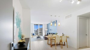 Una sala de estar moderna con comedor, ventanas amplias y vista a la ciudad.