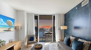 Un salón moderno con vistas a la ciudad, un balcón con mesa y sillas, y un gran mapa mural.