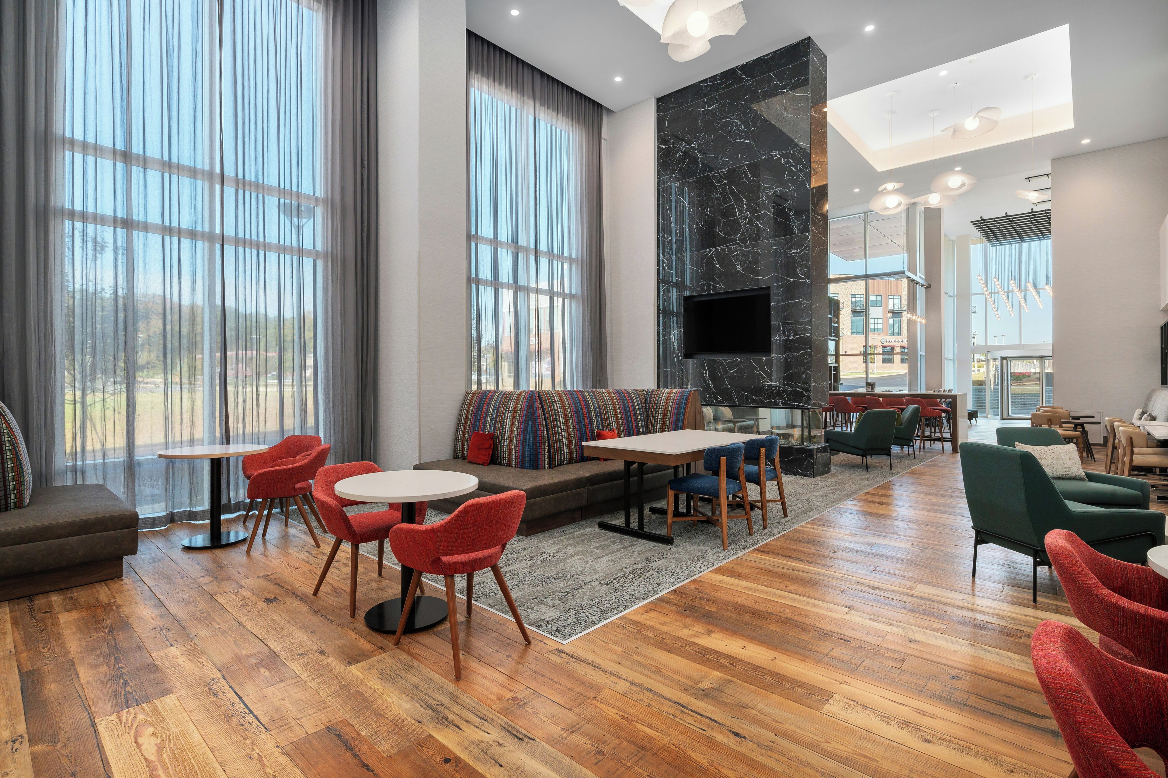 A modern lounge area with a fireplace, seating, and a view of the outside.