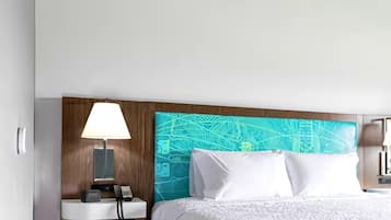 A hotel room with a bed, a nightstand with a lamp, and a wall with a circuit board design.