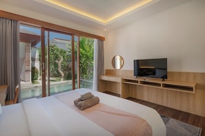 Habitación de hotel moderna con una cama grande, televisión y vistas a una piscina y jardín.
