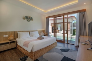 Een moderne hotelkamer met een groot bed, een bureau en uitzicht op een buitenzwembad.