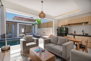Un salon moderne avec une piscine, un coin repas et une cuisine.
