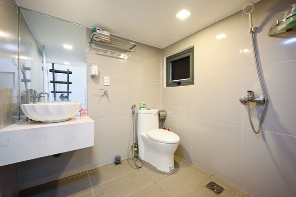 Un baño moderno con lavamanos, inodoro y ducha blancos.