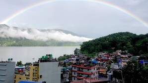 Una zona residencial con edificios, un lago y una cordillera al fondo.