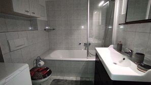 A modern bathroom with a bathtub, toilet, and sink. - Vacation apartment Cottbuser City (Cottbus)