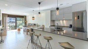 A modern kitchen with a central island, stainless steel appliances, and pendant lighting.