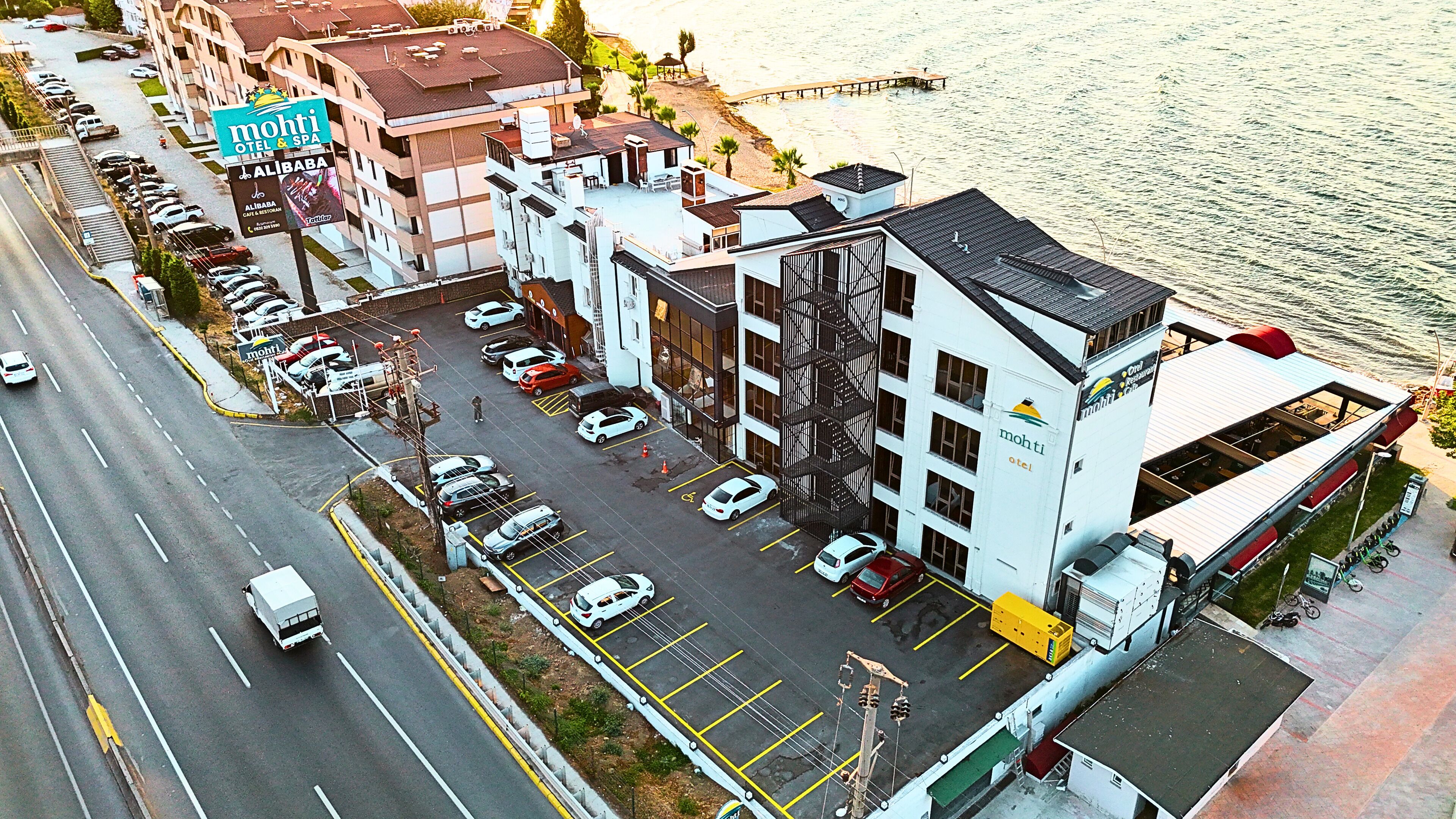 A waterfront hotel with a parking lot, a restaurant, and a view of the water.