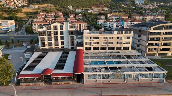 A hotel with a rooftop pool, multiple floors, and a prominent red cylindrical structure. - Mohti Otel (Karamürsel)