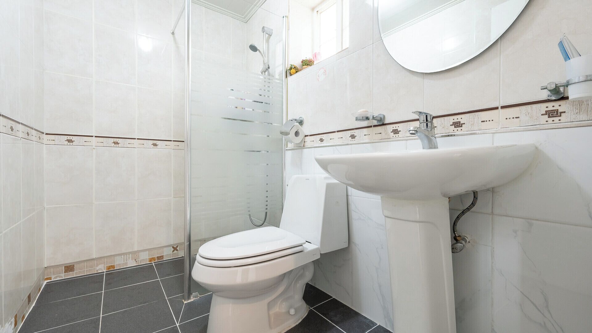 Un baño con inodoro, lavabo y ducha.