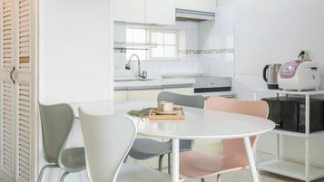 A modern kitchen with white cabinets, a stainless steel sink, and a coffee maker.